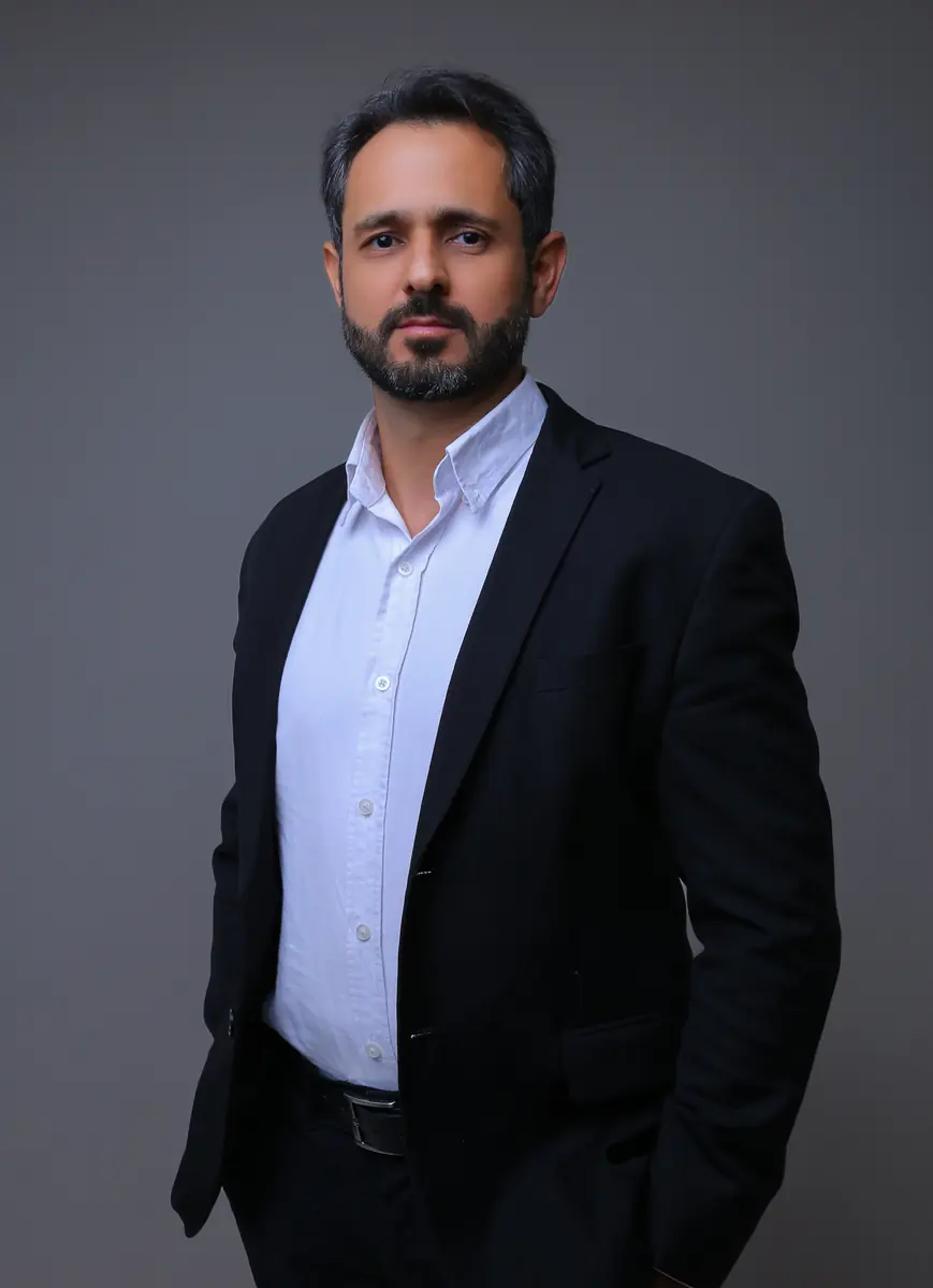 Mauro Vieira, advogado, de terno preto e camisa branca, em retrato de estúdio com a mão no bolso.